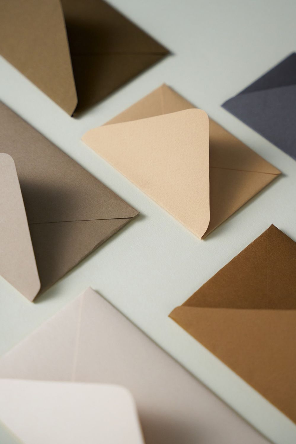 Elegante Geschenkboxen in verschiedenen neutralen Farbtönen wie Beige, Taupe und Braun auf weißem Hintergrund.